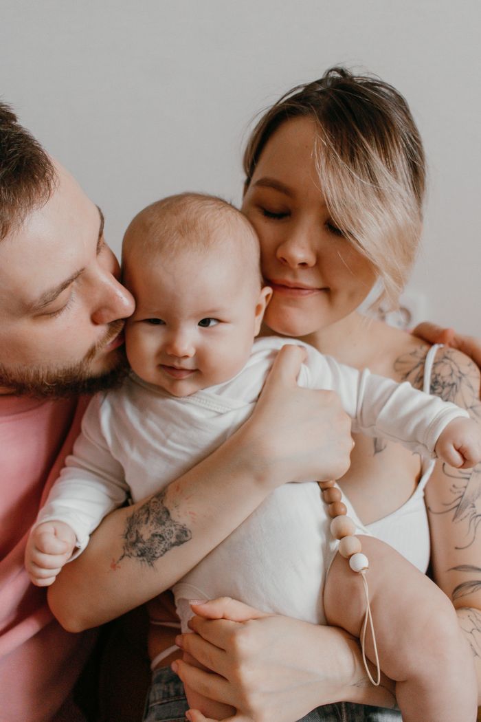 gallery-2 Heartwarming family portrait featuring parents and baby in an intimate embrace.