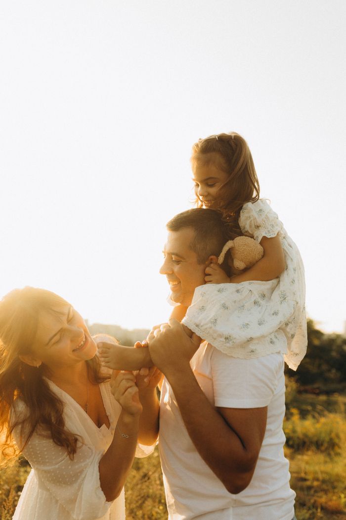 about-01 Joyful family enjoying a day outdoors, embracing happiness and togetherness under the warm sunlight.